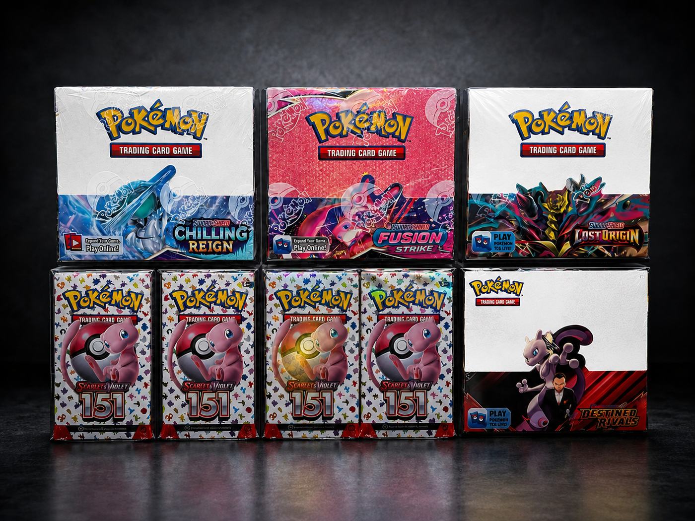 Pokemon sealed booster boxes and 151 boxes arranged on a dark surface